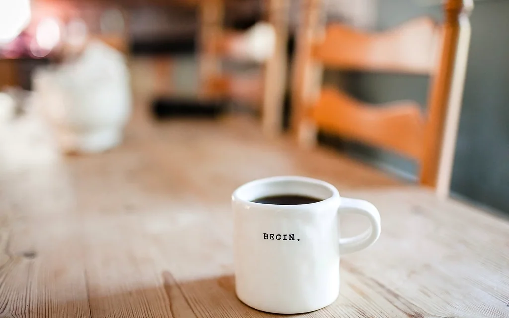 A white mug of black coffee on a wooden table